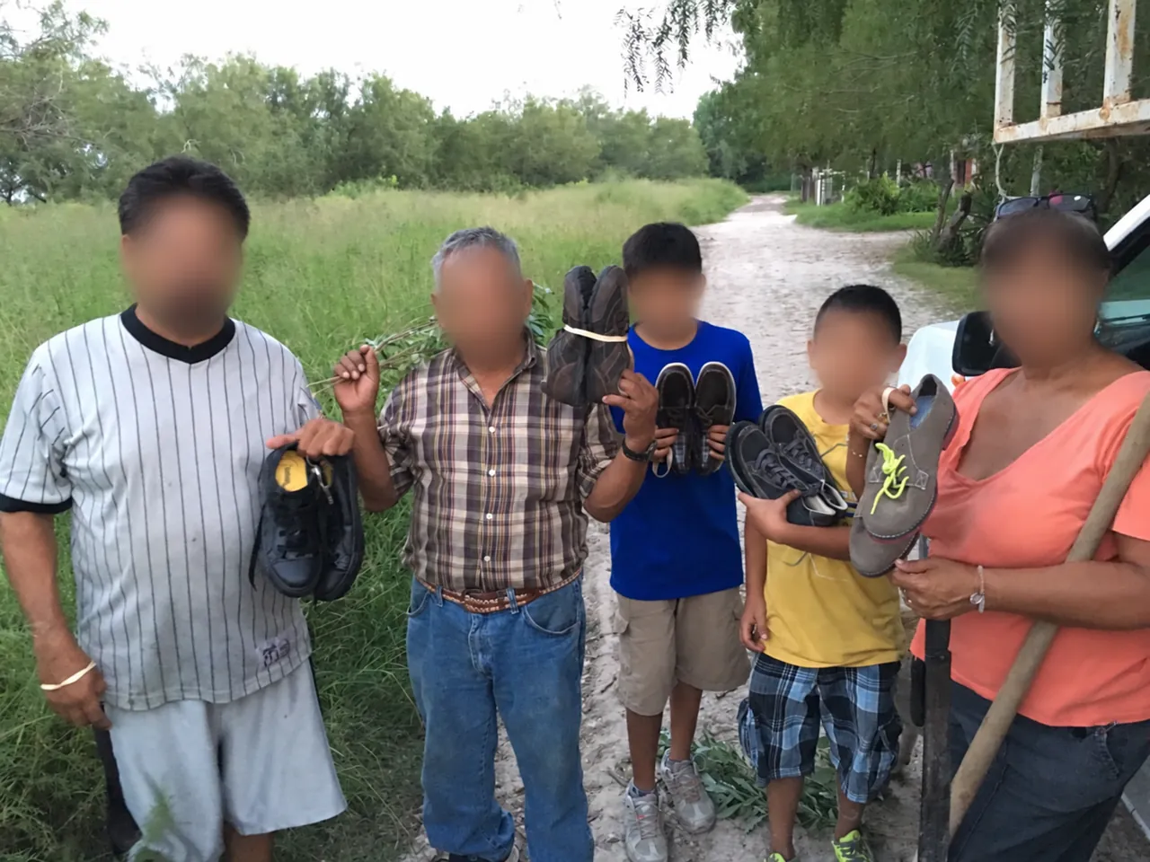 People holding donated footwear in Matamoras, with faces blurred.