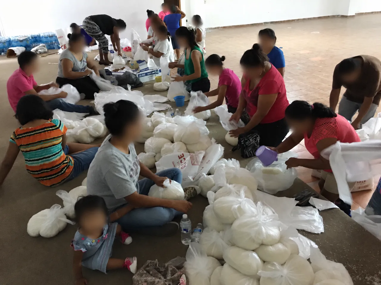 Volunteers preparing bags of rice for food assistance in Matamoras, with faces blurred.